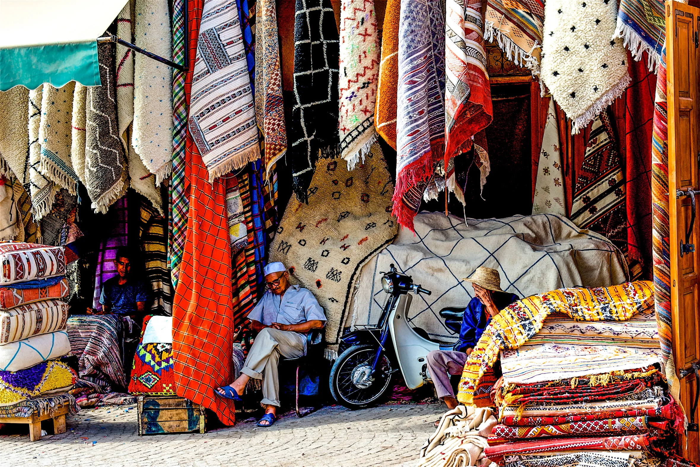 A rug merchant sitting in his stall in the Medina District of Marrakesh, Morocco.