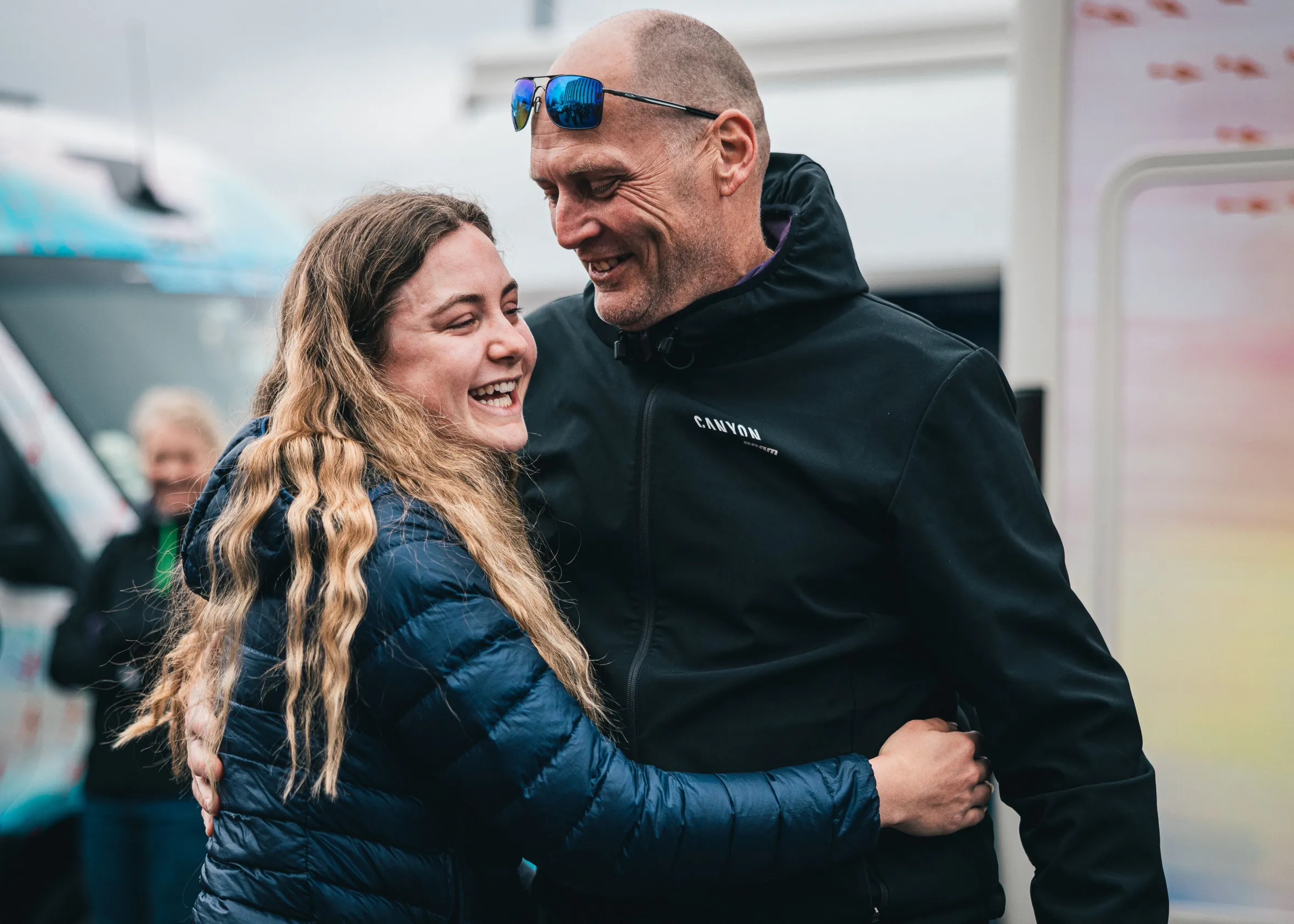 Zoe Backstedt and her dad Magnus embracing and laughing after a cycling race.