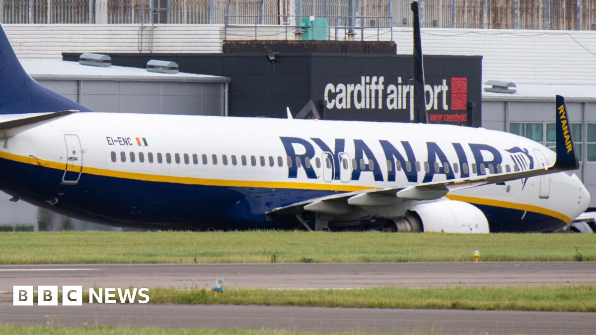 A Ryanair flight parked at Cardiff Airport, with the airport's logo seen in the background.