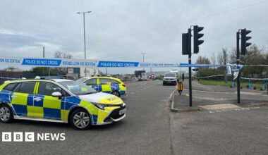 Two police cars and a police cordon on the intersection of a main road in Filton, north Bristol.
