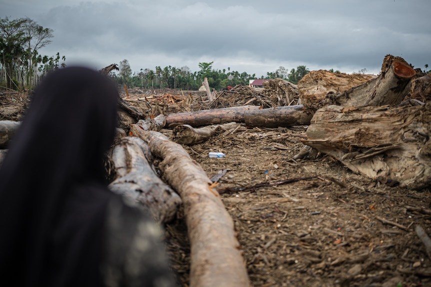 Rosniati looking out at a sea of destruction and debris.