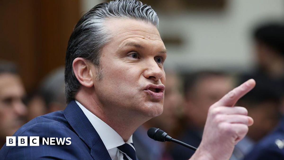A close photo of Pete Hegseth pointing his finger and speaking into a mic at a congressional hearing