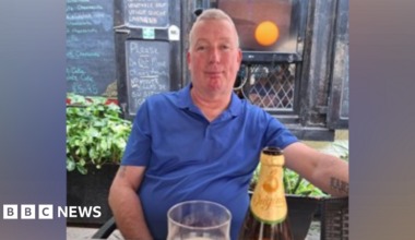Man sitting in pub wearing blue shirt