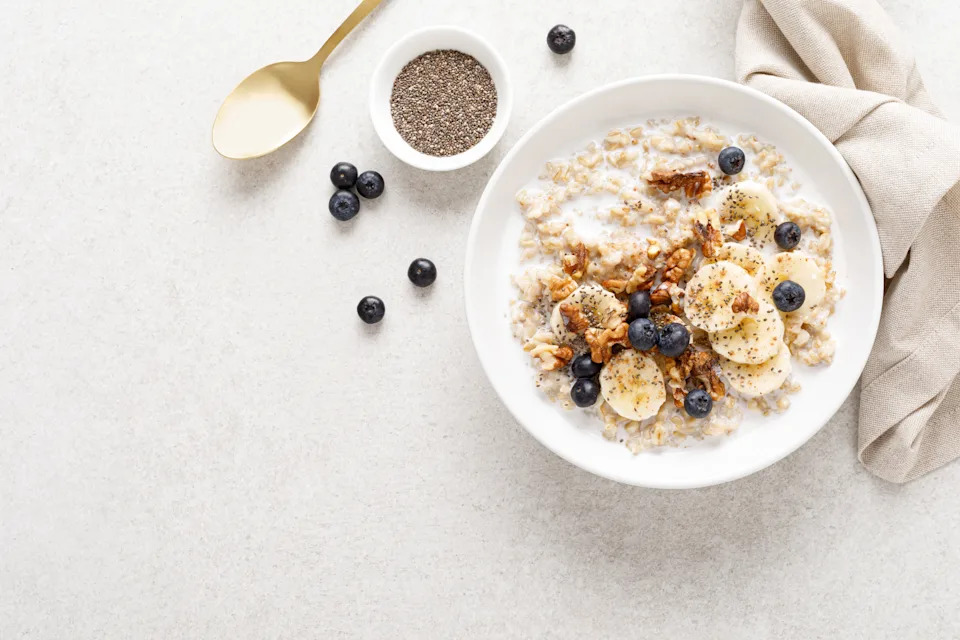 Oatmeal bowl. Oat porridge with banana, blueberry, walnut, chia seeds and almond milk for healthy breakfast or lunch. Healthy food, diet. Top view.