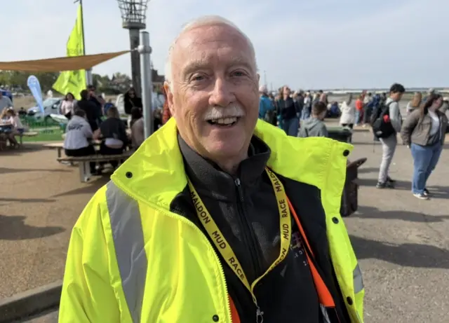 A man in hi vis smiles at the camera
