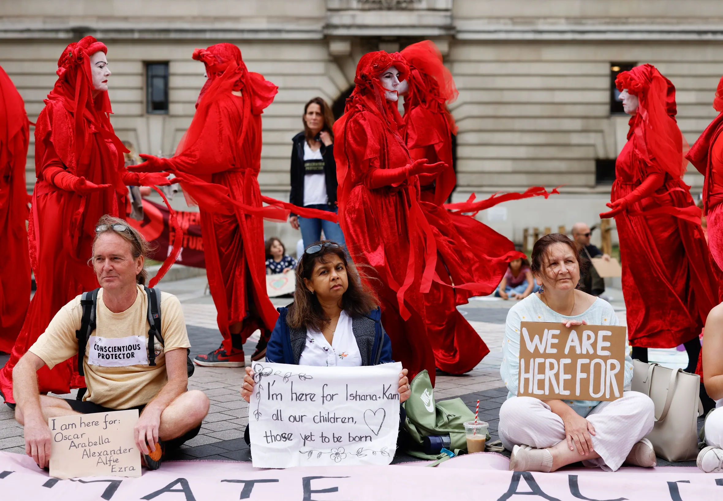 Protestors with signs "We are here for" at a climate change demonstration.