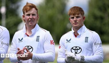 James (left) and Thomas Rew standing clapping their hands as they stand in a line during the national anthem before one of England Lions' matches