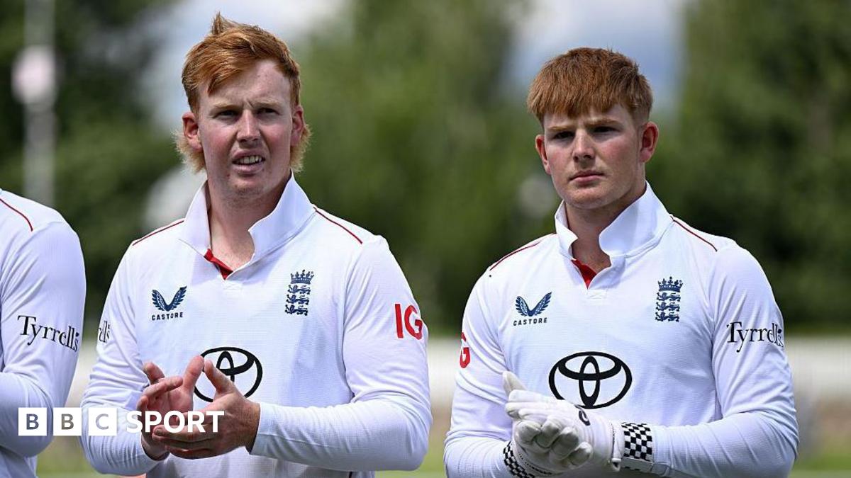 James (left) and Thomas Rew standing clapping their hands as they stand in a line during the national anthem before one of England Lions' matches