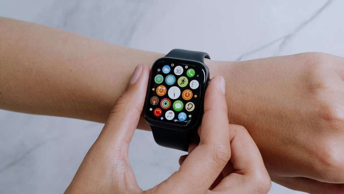 A woman adjusting her Apple Watch fitness tracking device on her wrist