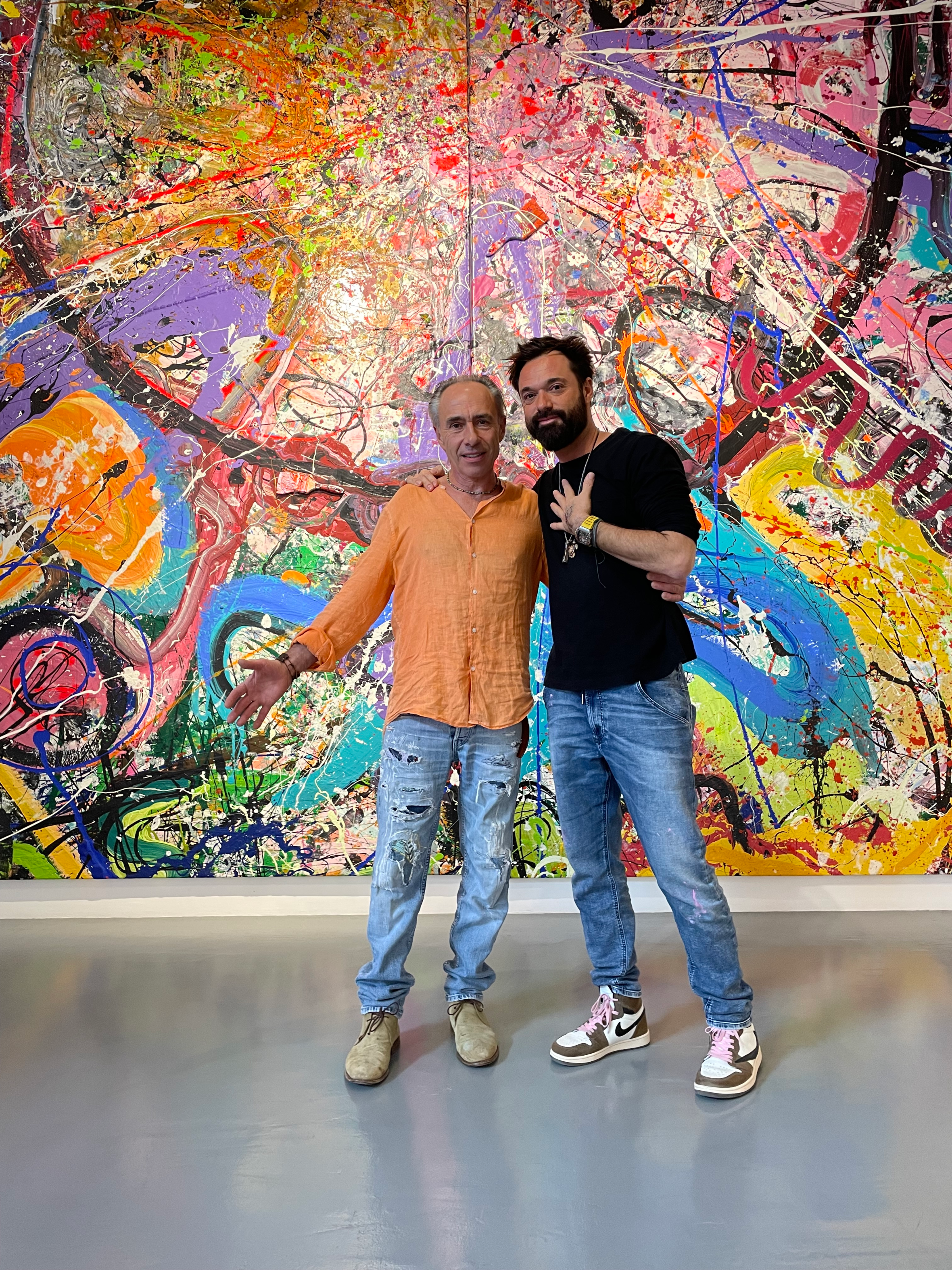 Clinton Pugh and Sacha Jafri pose in front of Jafri's abstract painting in his Dubai studio.