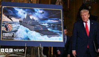 Donald Trump next to an image of the new Trum-class battleships.