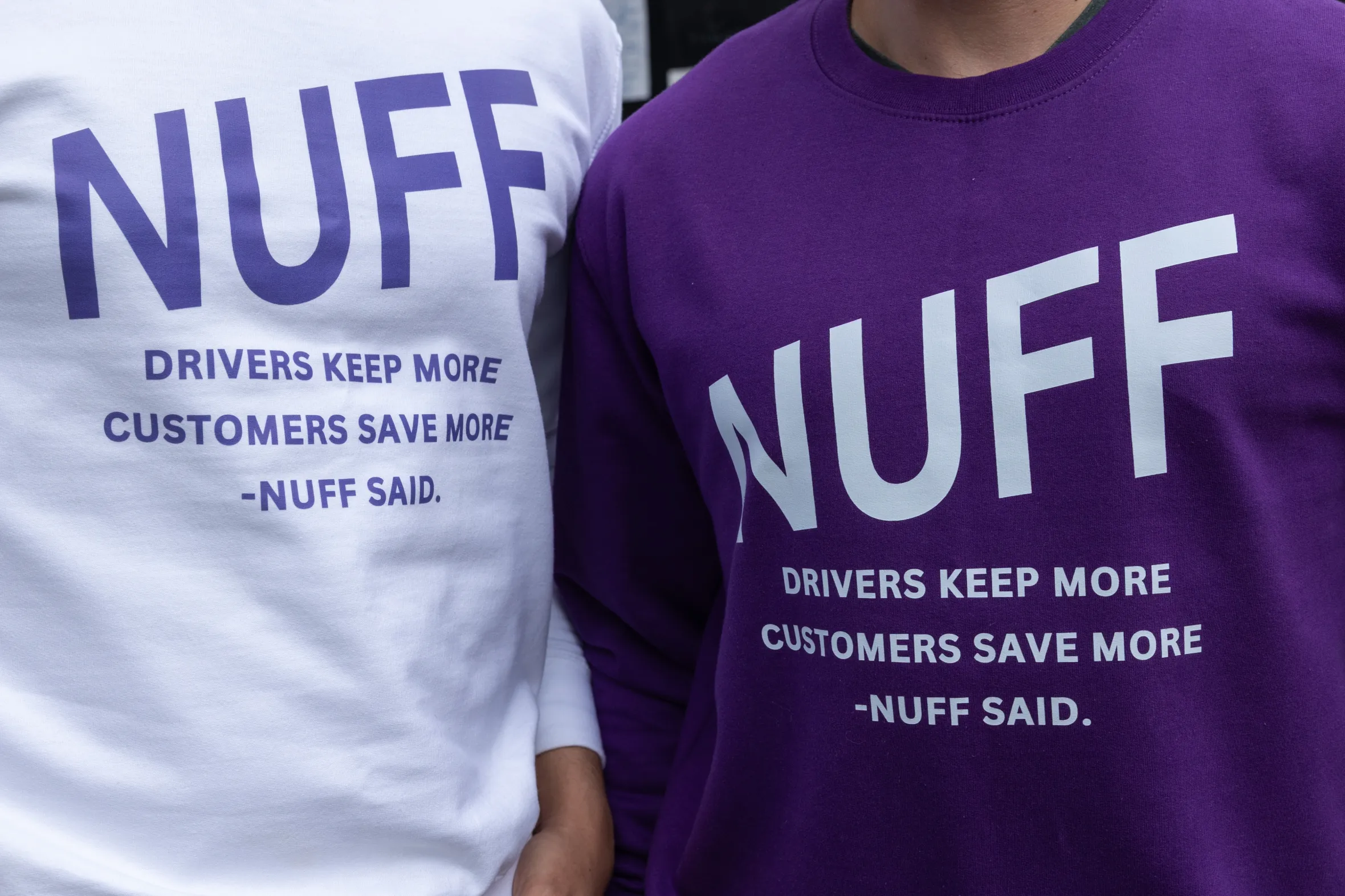 Two individuals wearing jumpers with "NUFF" branding, which also states "DRIVERS KEEP MORE CUSTOMERS SAVE MORE -NUFF SAID." One jumper is white with purple text, and the other is purple with white text.