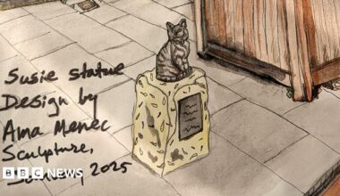An ink and pen sketch of the cat statue. The tabby cat is sitting on a low stone plinth on the pavement next to a wooden planter. A handwritten note reads: Susie statue design by Ama Menec Sculpture, January 2025.