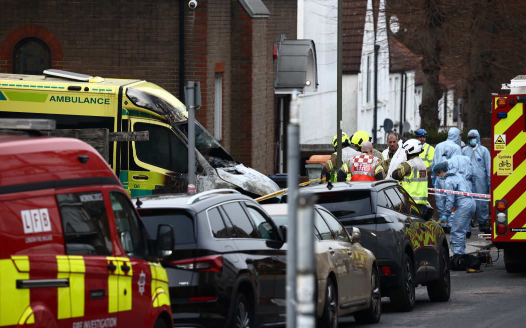 Police forensic officers and members of the emergency services work at the scene of an antisemitic arson attack in the Golders Green neighbourhood of north London on March 23, 2026, an incident where volunteer ambulances run by a Jewish organisation were set on fire. Britain's Prime Minister Keir Starmer on March 23 condemned "a deeply shocking antisemitic arson attack" on volunteer ambulances run by a Jewish organisation in London. (Photo by Henry NICHOLLS / AFP)