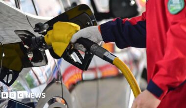 A person holds a gas pump and refuels a car at a gas station in Fuyang City, Anhui Province, China, on April 7, 2026.