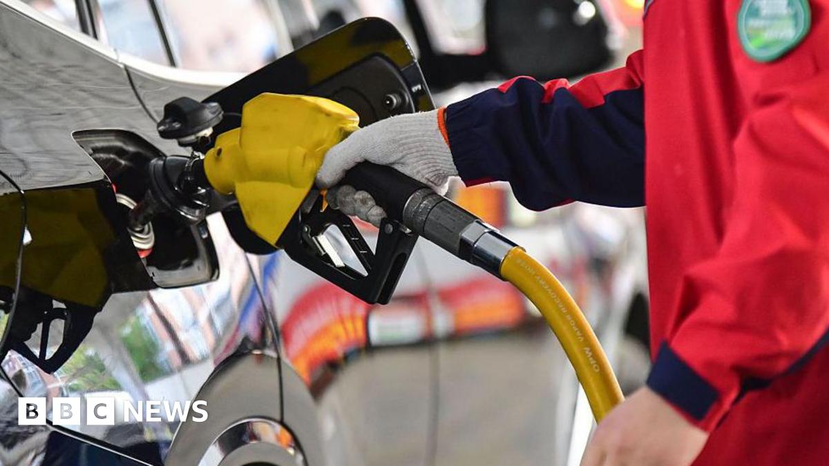A person holds a gas pump and refuels a car at a gas station in Fuyang City, Anhui Province, China, on April 7, 2026.