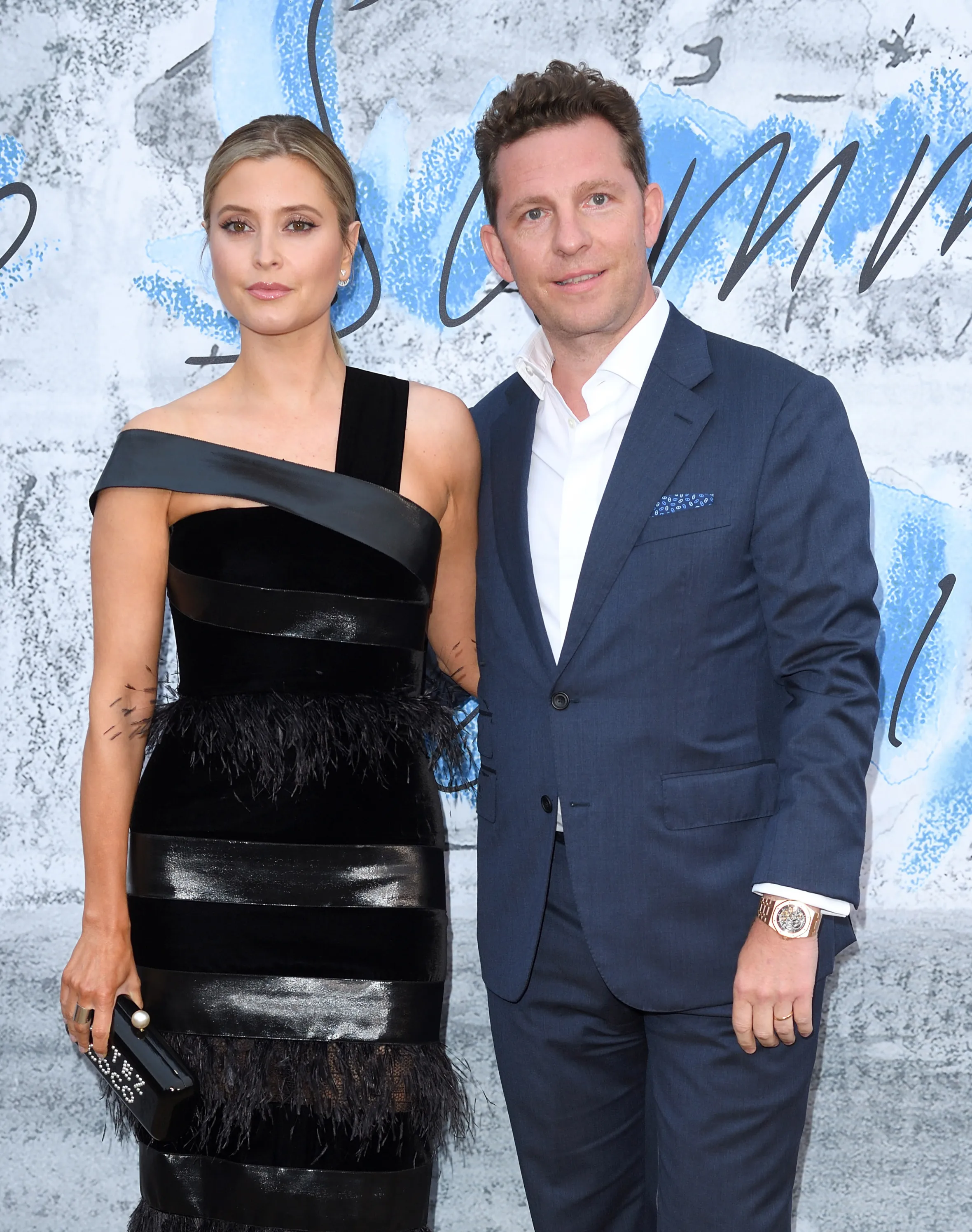 Holly Valance in a black feather-trimmed dress and Nick Candy in a navy suit attending The Summer Party 2019.