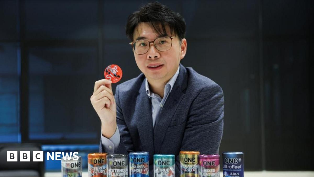 CEO of condom manufacturer Karex, Goh Miah Kiat, poses with condoms manufactured by the company in Malaysia