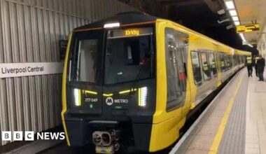 A yellow train car at Liverpool Central station platform