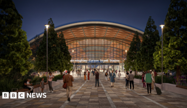 An artist's impression of the new Curzon street station, showing people outside a huge arch entrance with "Birmingham Curzon Street Station" in bold white signage.