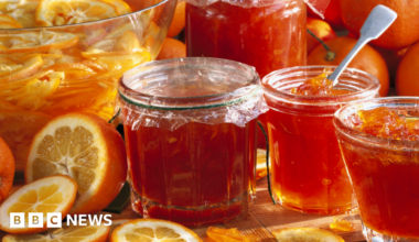 Jars of marmalade with Seville oranges in the background