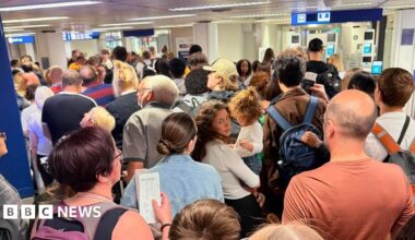 A large queue of people waiting in an airport.