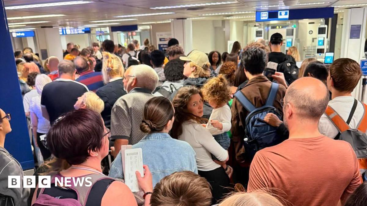 A large queue of people waiting in an airport.