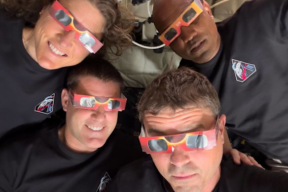 The Artemis II crew pose with eclipse-viewing glasses.
