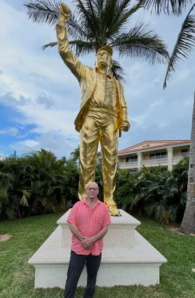 Alan Cottrill standing next to his golden Donald Trump statue at Doral.