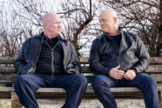 Phil and Grant Mitchell facing each other while sat on a bench