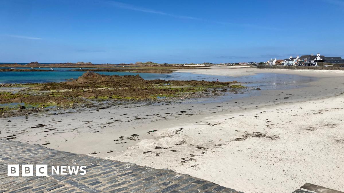 The picture shows Cobo beach on Guernsey's west coast on a sunny day with a blue sky