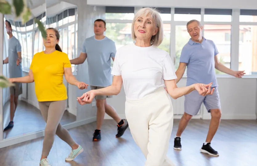 Group of senior adults rehearsing sports dance in dance class