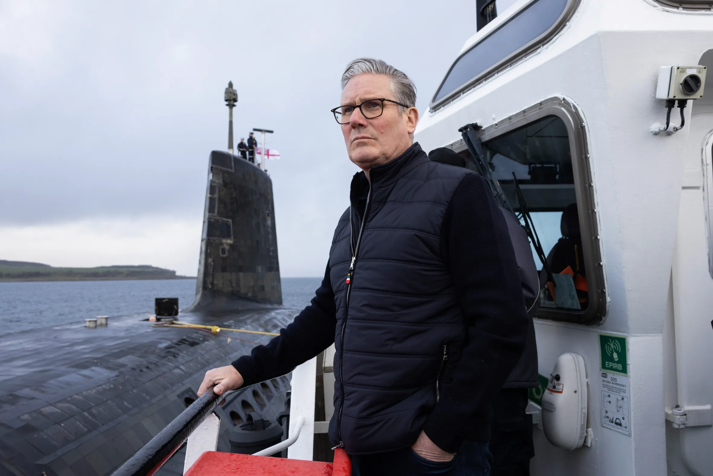 Prime Minister Keir Starmer on a ship next to a large submarine.