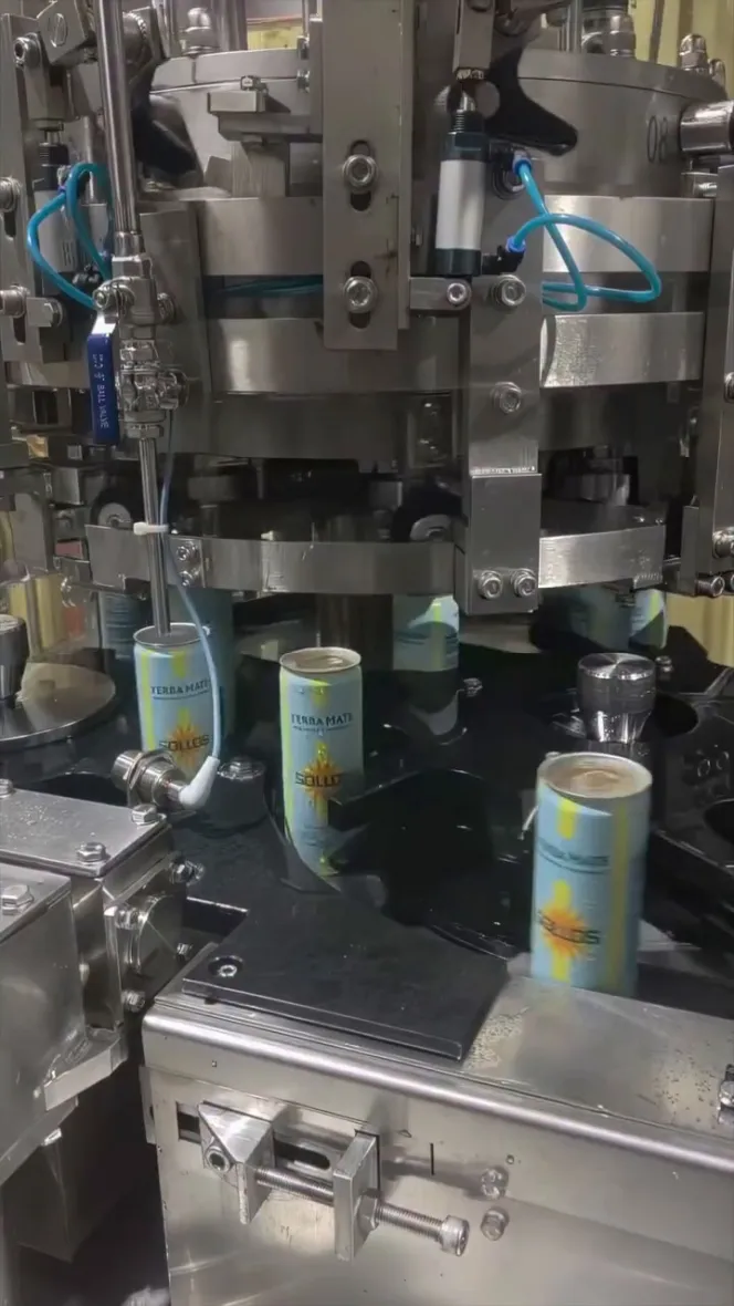 Sollos Yerba Mate cans being filled and capped on an assembly line.