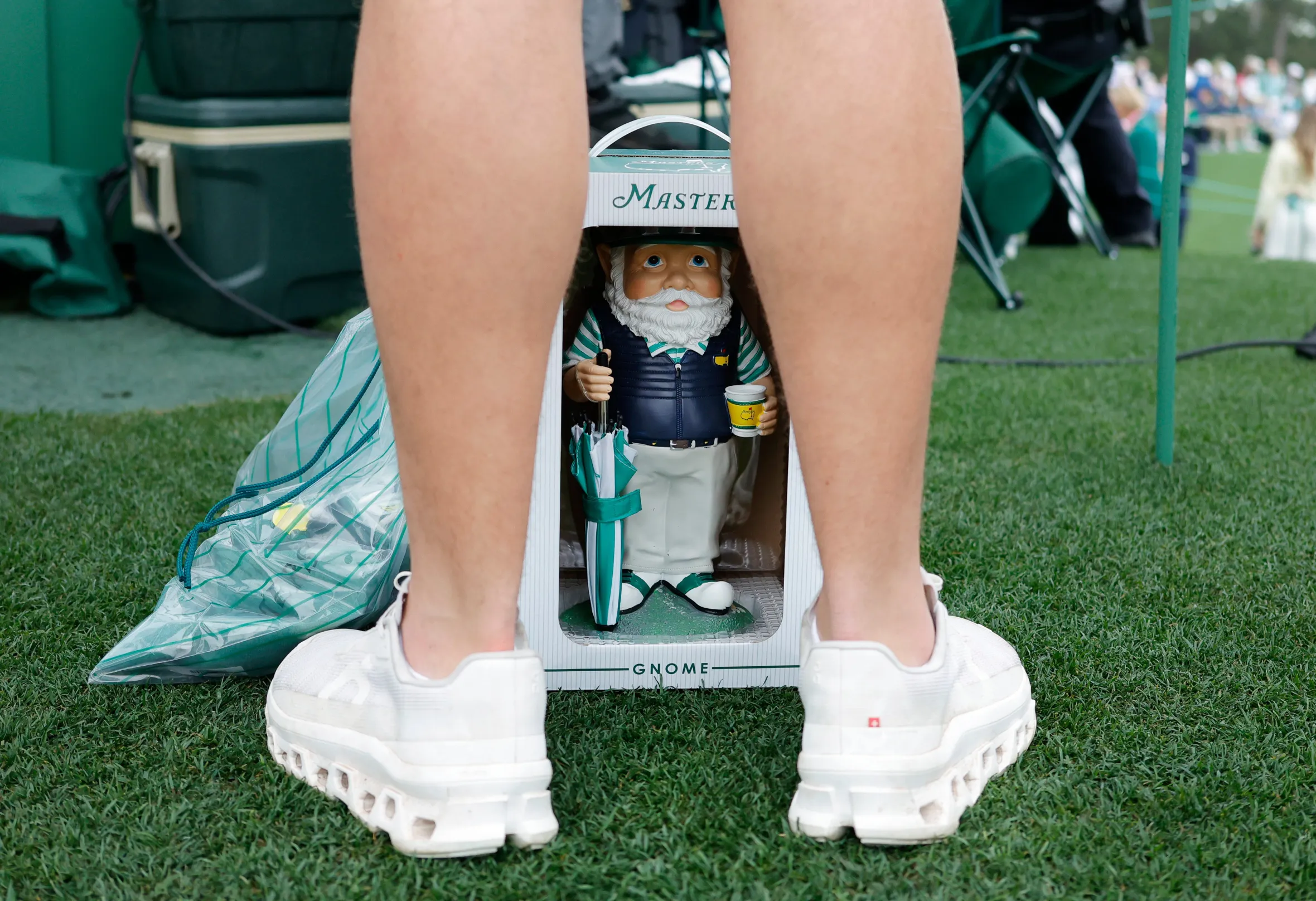 A patron stands with a Masters Gnome at Augusta National Golf Club.