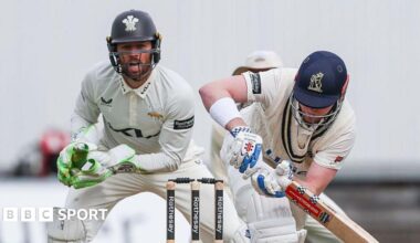 Left-handed Dan Mousley watchfully turns a ball to the legside as Surrey wicketkeeper Ben Foakes watches behind the stumps