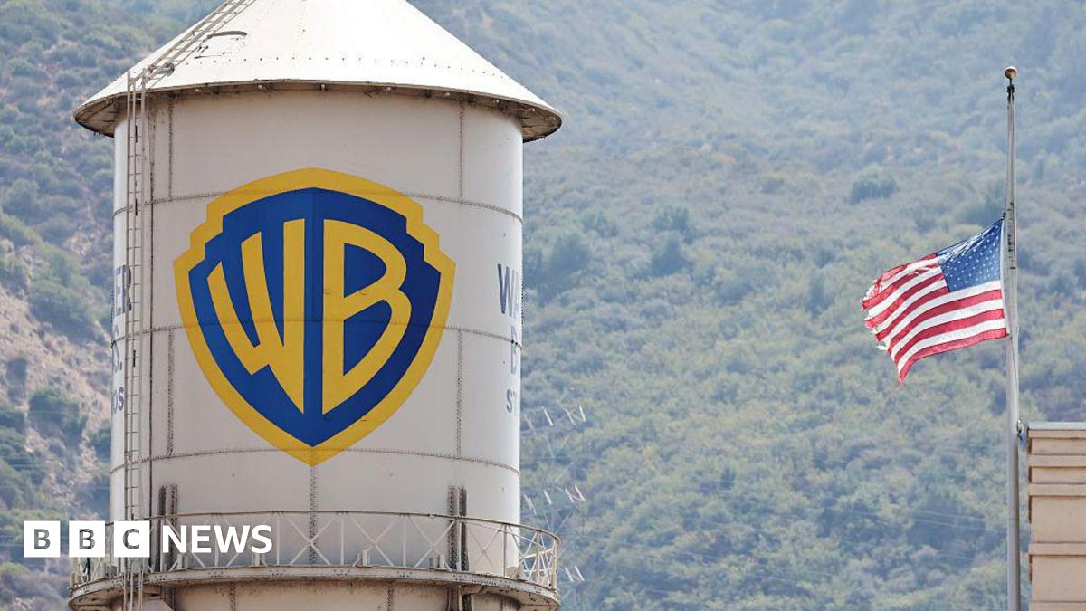 A water silo with the Warner Bros logo on it next to a US flag.