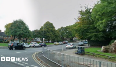 A junction between two roads, pictured in the daytime from Google Street View.