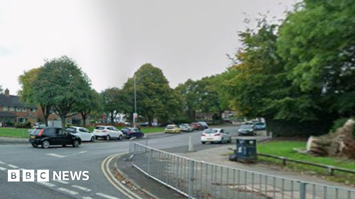 A junction between two roads, pictured in the daytime from Google Street View.