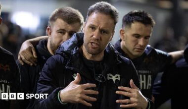 Ospreys head coach Mark Jones gestures with his hands as he talks to his squad in a huddle