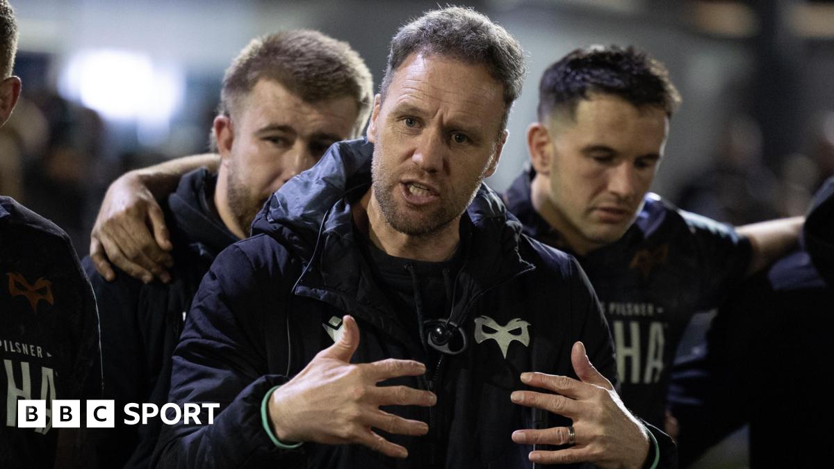 Ospreys head coach Mark Jones gestures with his hands as he talks to his squad in a huddle