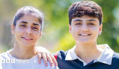 Atefeh Ramezanisadeh (L) and Fatemeh Pasandideh pose for a photo, blurred greenery in the background