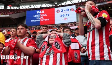 Dozens of Sheffield United fans, mostly dressed in red and white club shirts, look on in anguish in the lower tier behind the goal at Wembley Stadium during the Championship play-off final moments before their second goal against Sunderland was disallowed by VAR for offside.