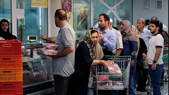 Shoppers queue at a butcher’s counter in Iran as food costs continue to climb.
