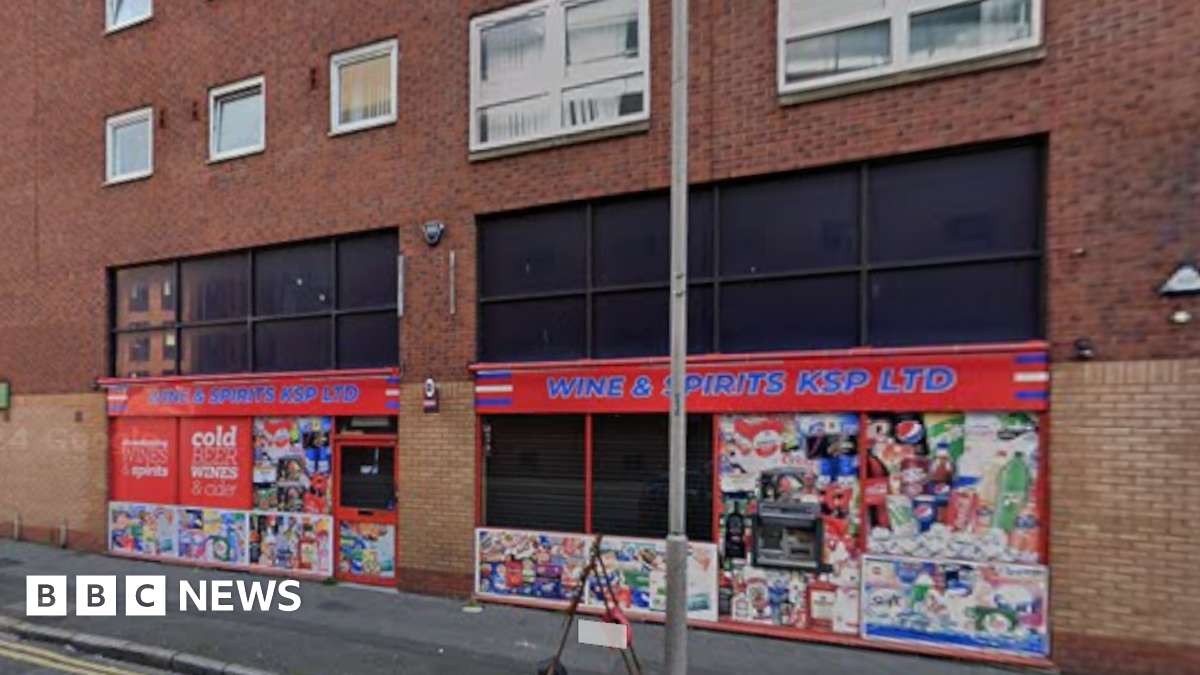 Exterior of Wines and Spirits KSP. It has red signage and multiple advertisements on the windows.