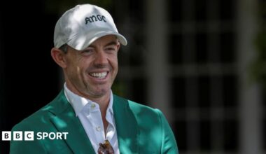 Rory McIlroy smiles as he talks to Augusta officials on his return to the Masters