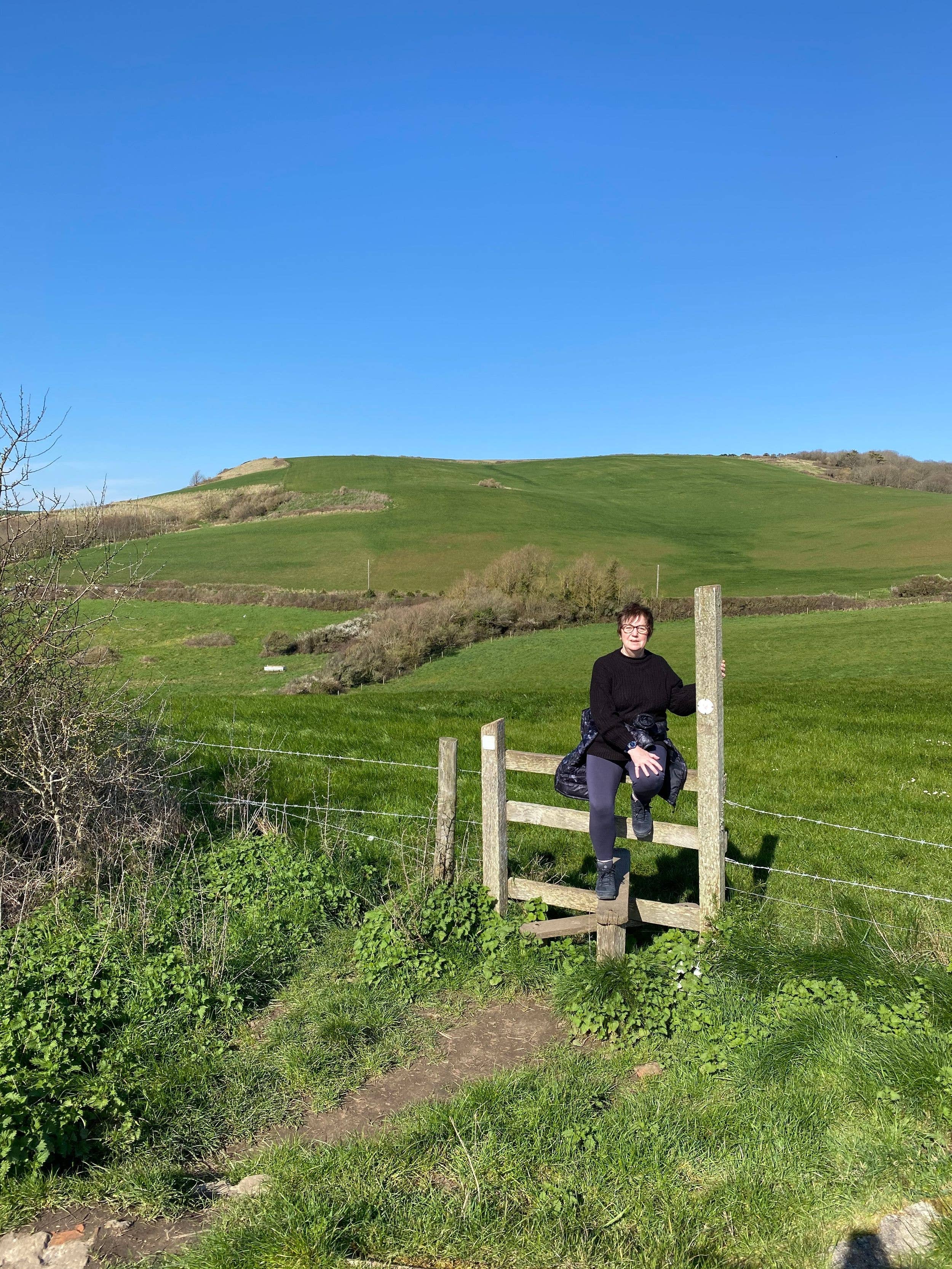 woman sitting on a stile during a walk 