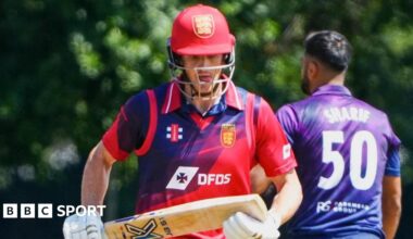 Zak Tribe holding a cricket bat during a game.