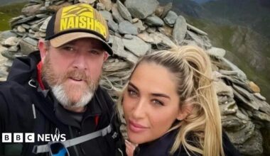 Tim Edwards, wearing a baseball cap, poses for a photograph with his blonde-haired daughter Elle. They are standing at the top of Mount Snowdon.