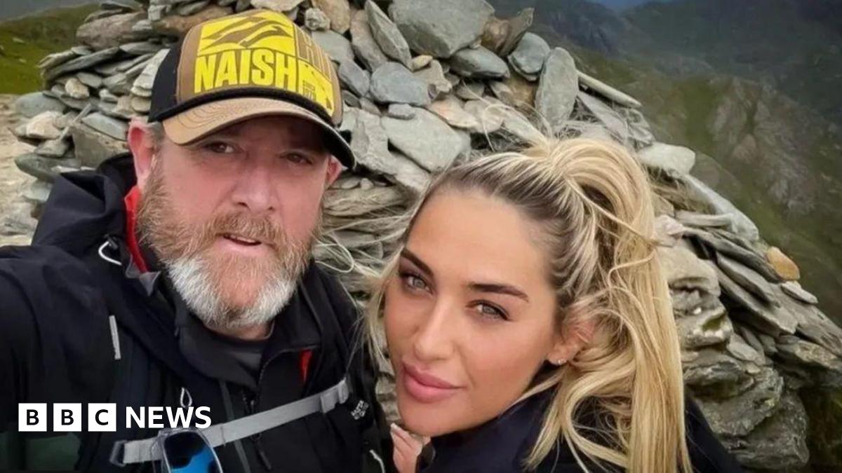 Tim Edwards, wearing a baseball cap, poses for a photograph with his blonde-haired daughter Elle. They are standing at the top of Mount Snowdon.